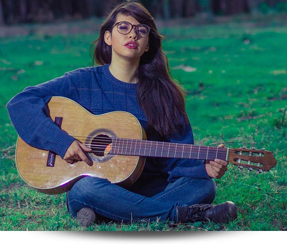 دختر در حال نواختن گیتار در طبیعت
