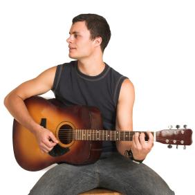 man sat down holding an acoustic guitar