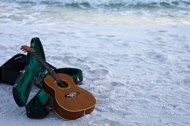 Classical guitar lying in the sand